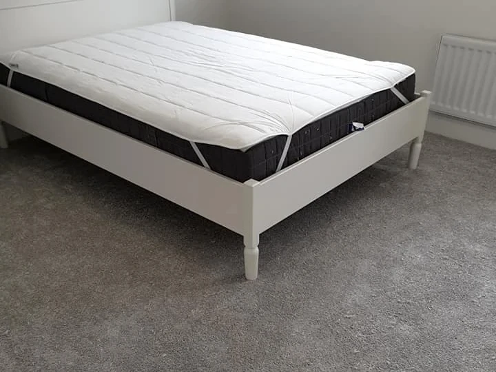 Grey carpet fitted around a white bed frame, Newcastle