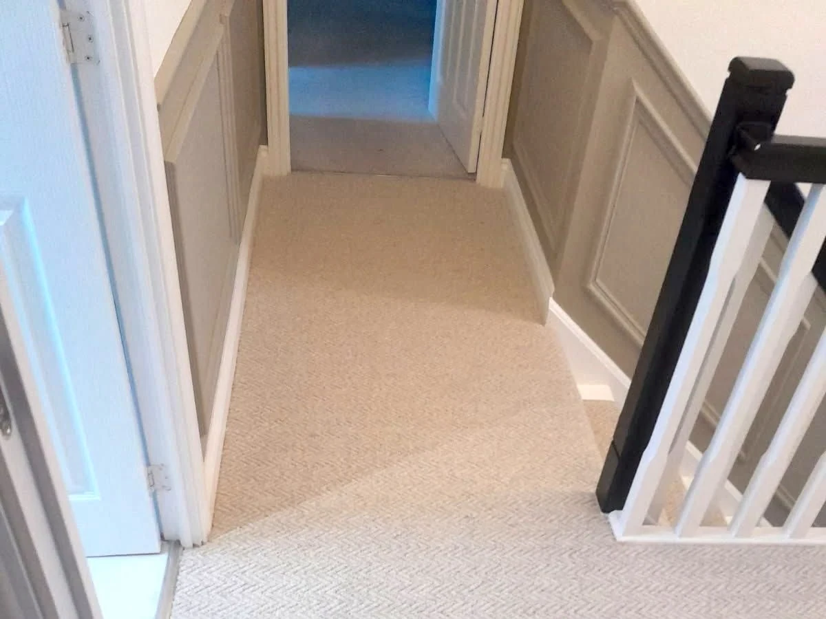 Landing carpet fitted around panelled walls — tidy multi-trade finish