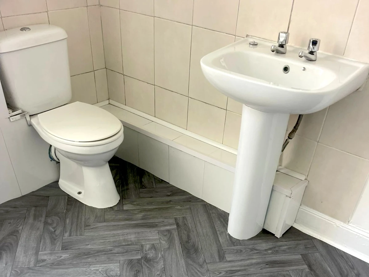 Grey herringbone-effect vinyl flooring in a bathroom