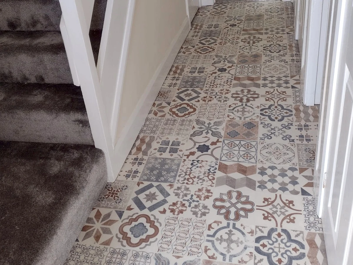 Patterned vinyl flooring beside carpeted stairs
